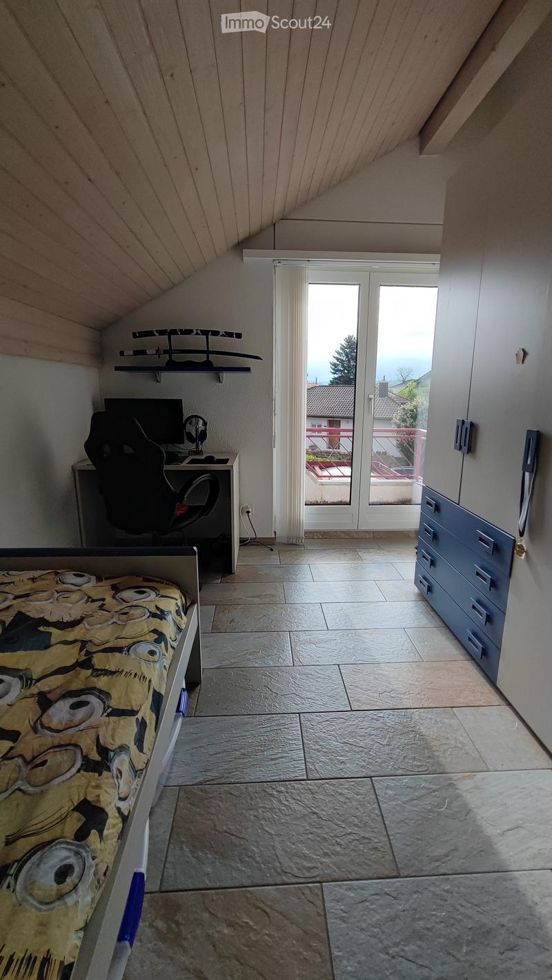 Bed, wooden desk with computer, black office chair, blue wardrobe with drawers, sword decor on the wall, balcony with fence.
