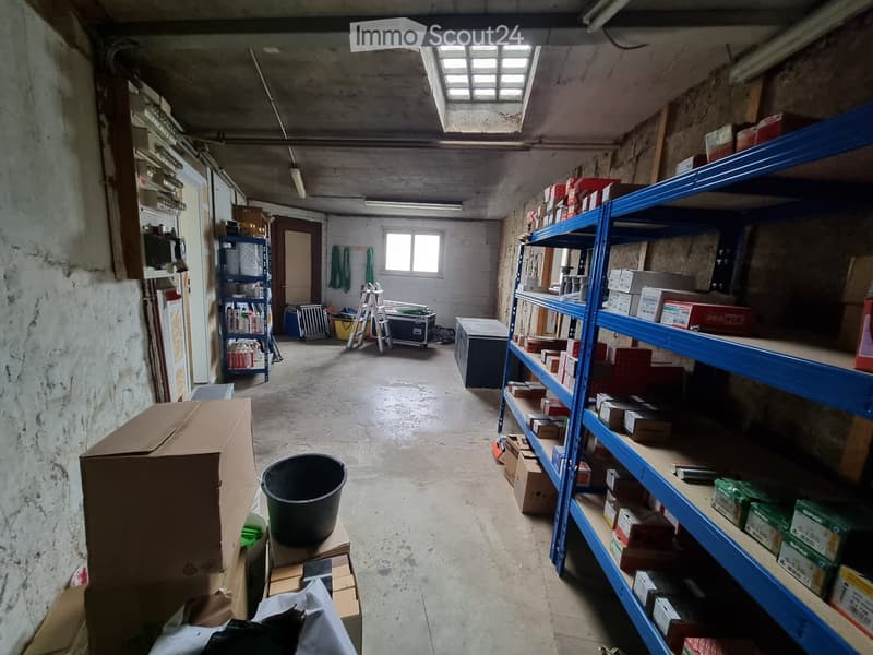 Storage room with shelves, boxes, buckets, ladder, and a window