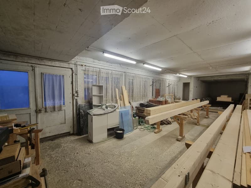 empty room, concrete floor, white walls, wooden beams, windows, door, sink, shelves, tools, buckets
