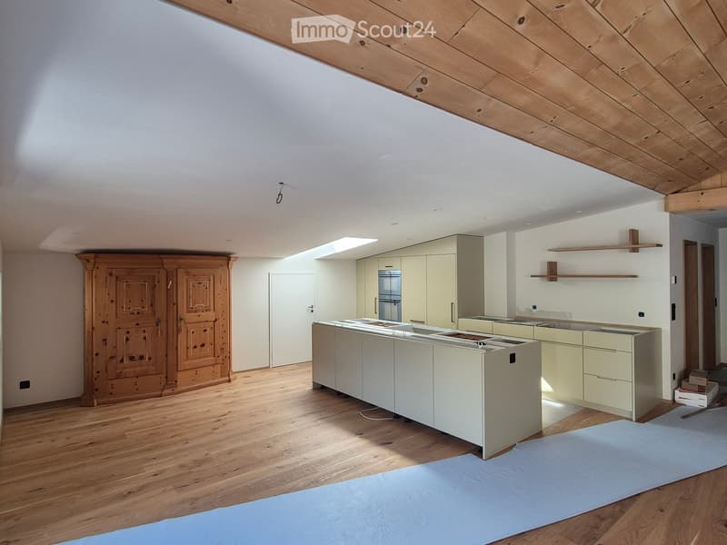 Modern kitchen with light-colored cabinets, a central island, and wooden flooring. The space features built-in storage and a sleek design.
