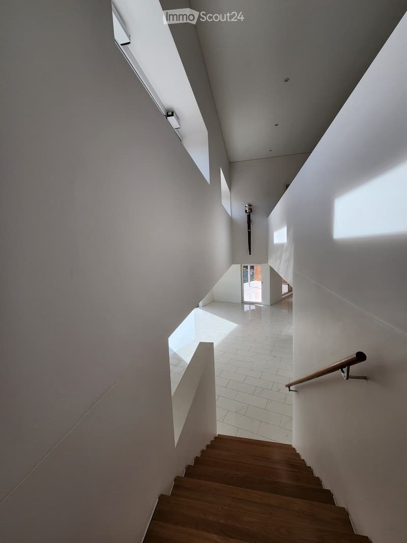 modern interior with white walls, wooden staircase, tiled flooring, railings