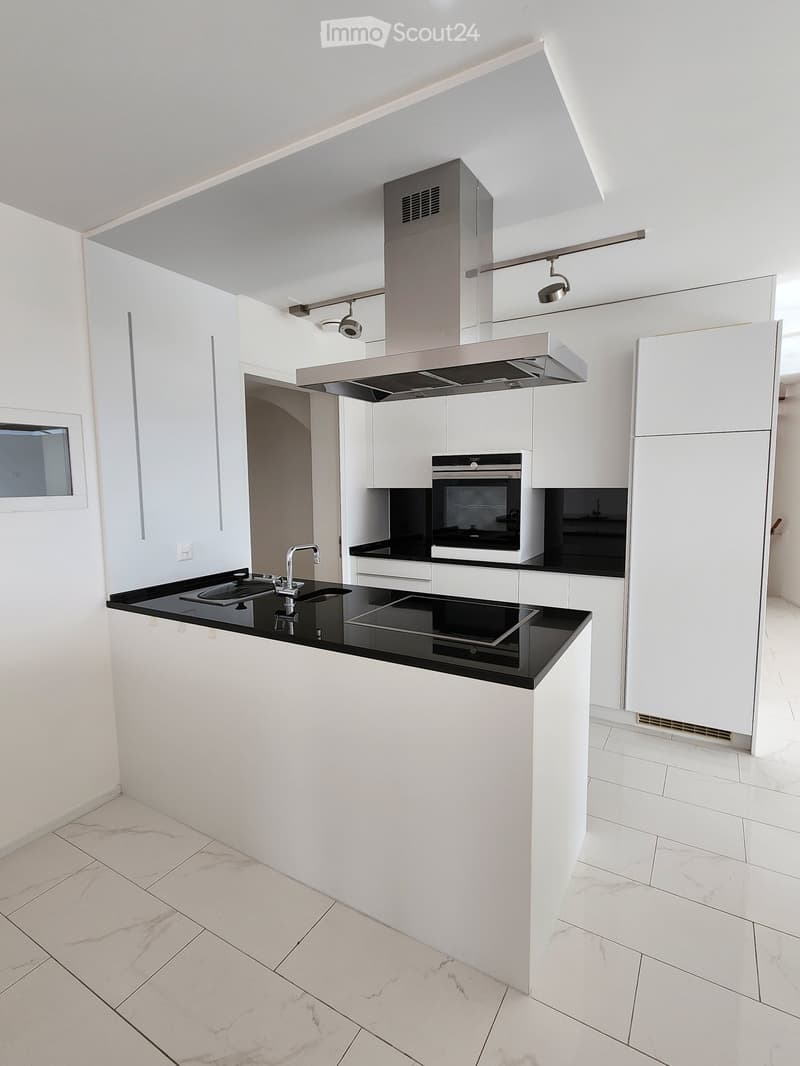 modern kitchen with white cabinets, black marble countertops, induction stove, oven, integrated extractor hood, stainless steel faucet, built-in dishwasher, tiled floor
