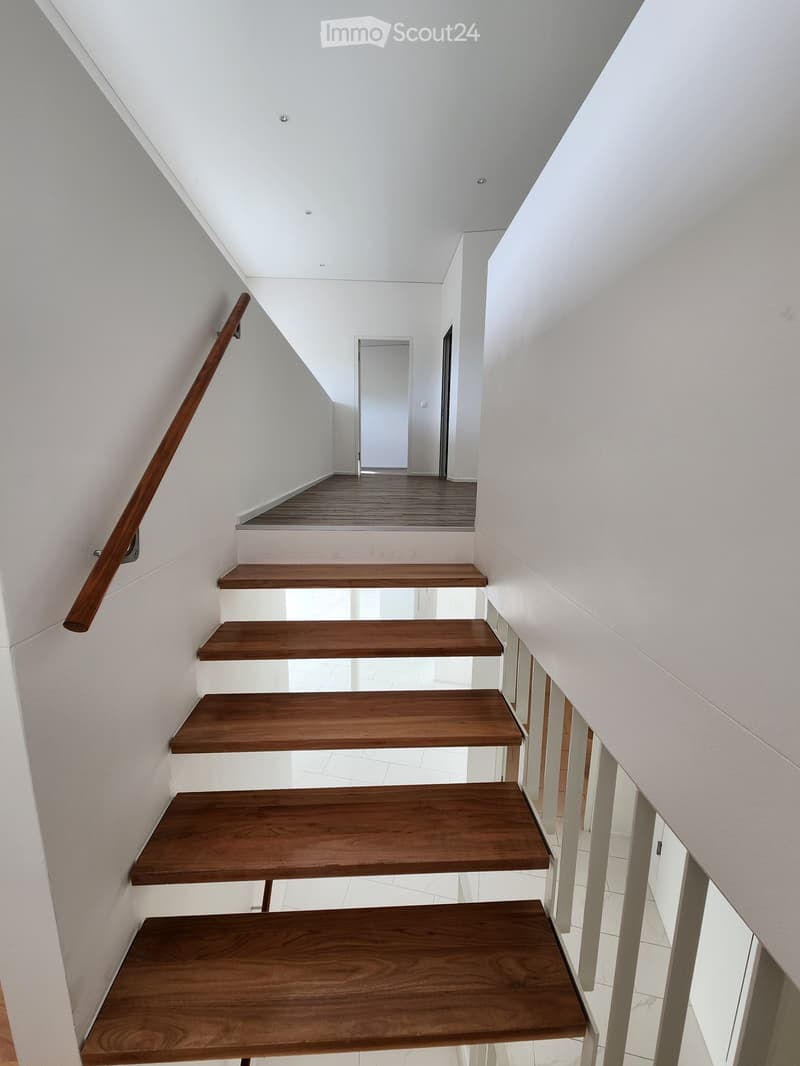 Wooden staircase, white tiled floors, white walls, open space, two doors