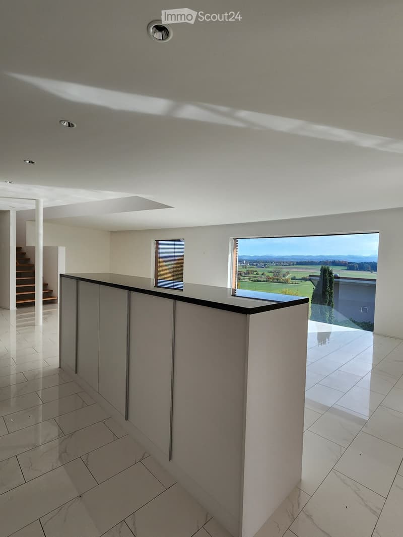 kitchen with a marble top island, tile flooring, white cabinets, large windows, stairs, balcony