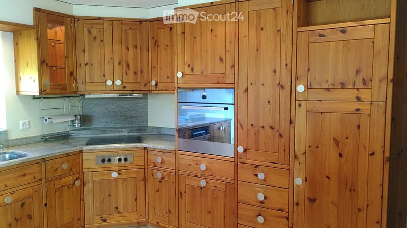 Wooden kitchen with multiple cabinets, an oven, a sink, and a stove, all featuring a warm, natural wood finish.