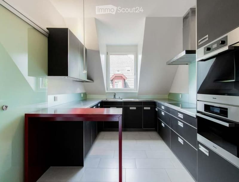 modern kitchen, black cabinets, white countertops, red table, stainless steel appliances, window
