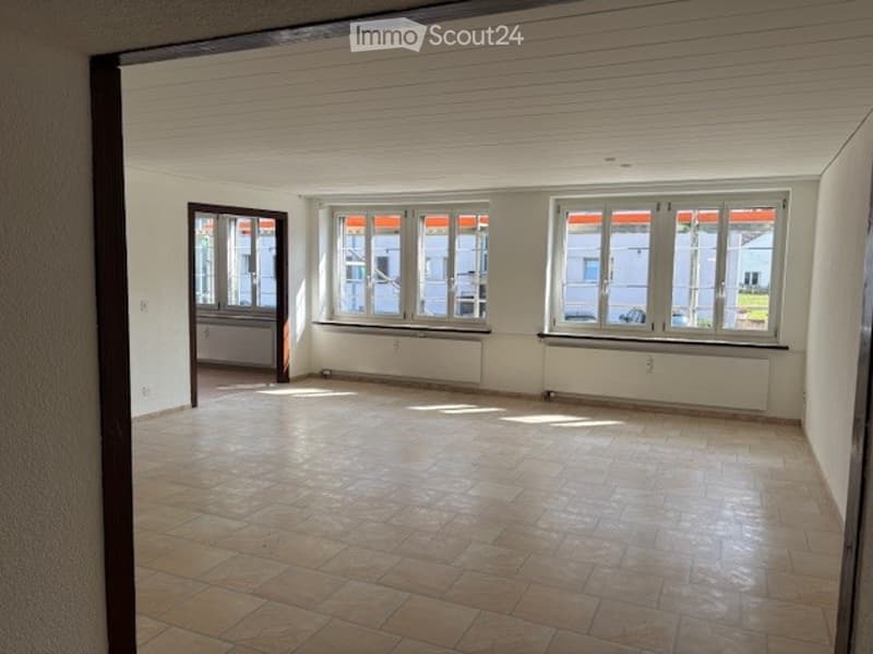 Empty room with tiled floor, three windows, white walls, and white ceiling.
