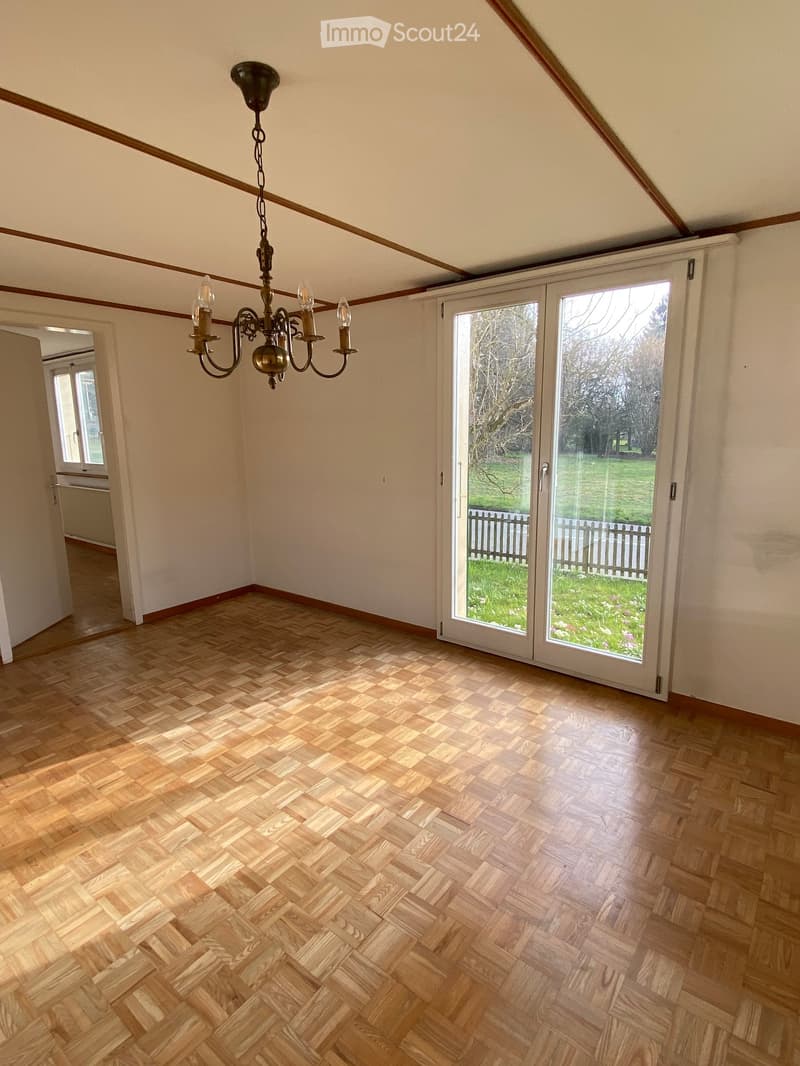 empty room, wooden parquet floor, chandelier, sliding glass doors, white walls, open door