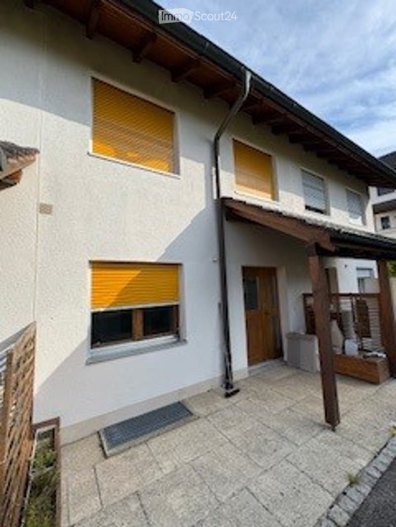white house, yellow shutters, wooden door, wooden awning, paved entrance