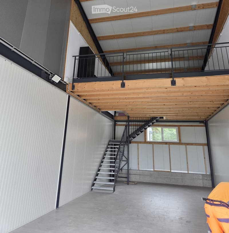 Empty building with wooden ceiling, metal railings, stairs, and a window