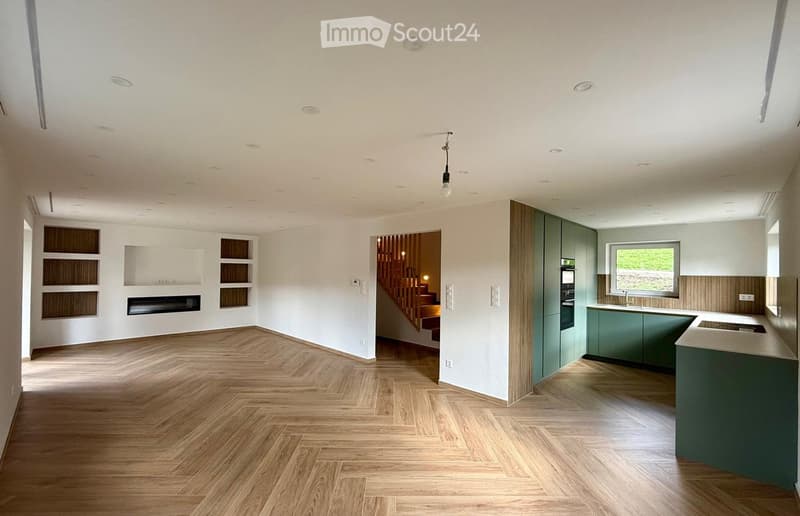 open floor plan, wooden flooring, white walls, fireplace, kitchen, staircase