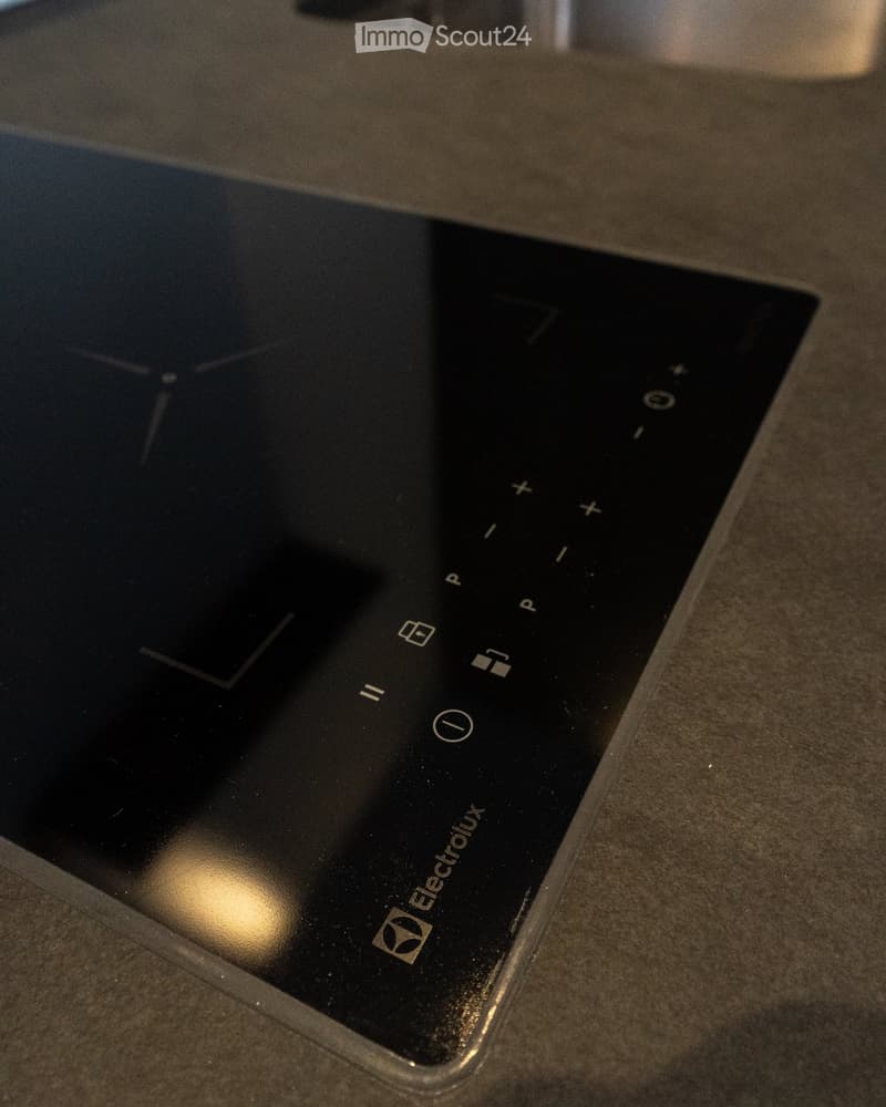 Electrolux induction cooktop, black surface, touch controls, brand logo on the bottom