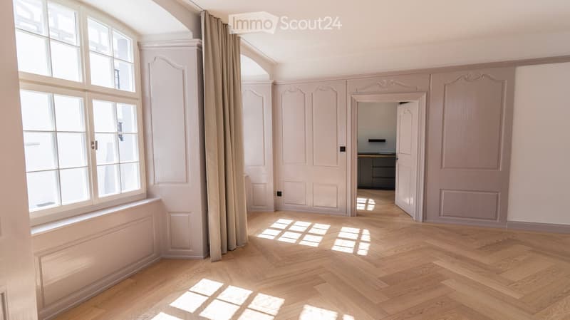 large window, wooden floor, white walls, open door