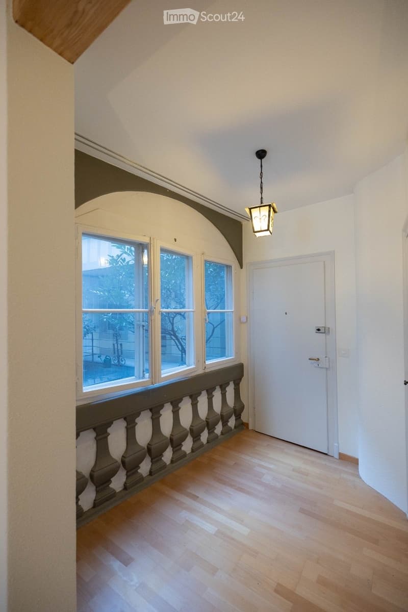 empty room, wooden floor, white walls, arched window, balcony, hanging lamp