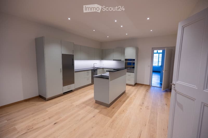 modern kitchen with island, white cabinets, stainless steel appliances, wooden floor, recessed lighting