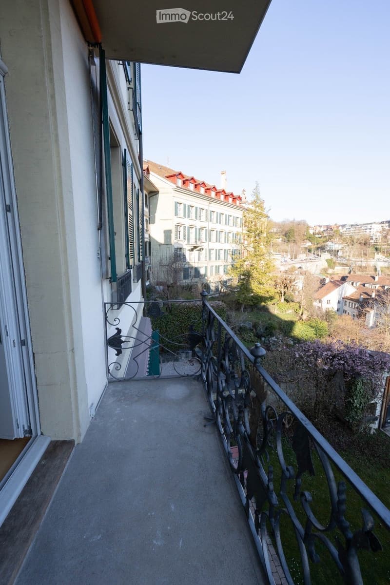 balcony with wrought iron railing, concrete floor, view of the city
