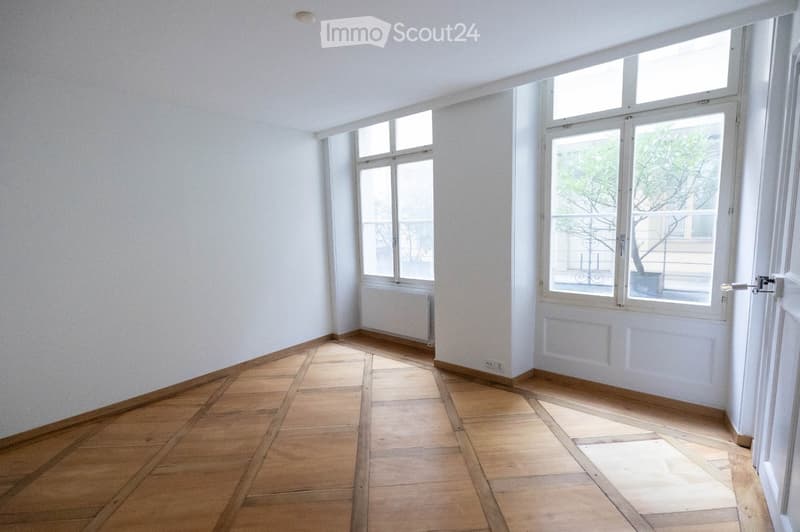 empty room, wooden floor, white walls, two windows, radiator