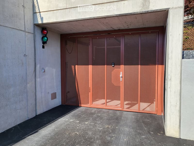 concrete walls, red metal garage door, traffic light