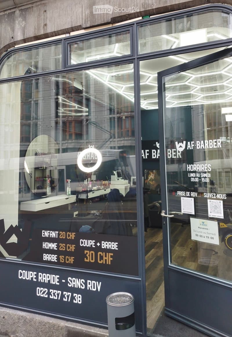 Barber shop entrance with glass door, large window, trash bin, and price list