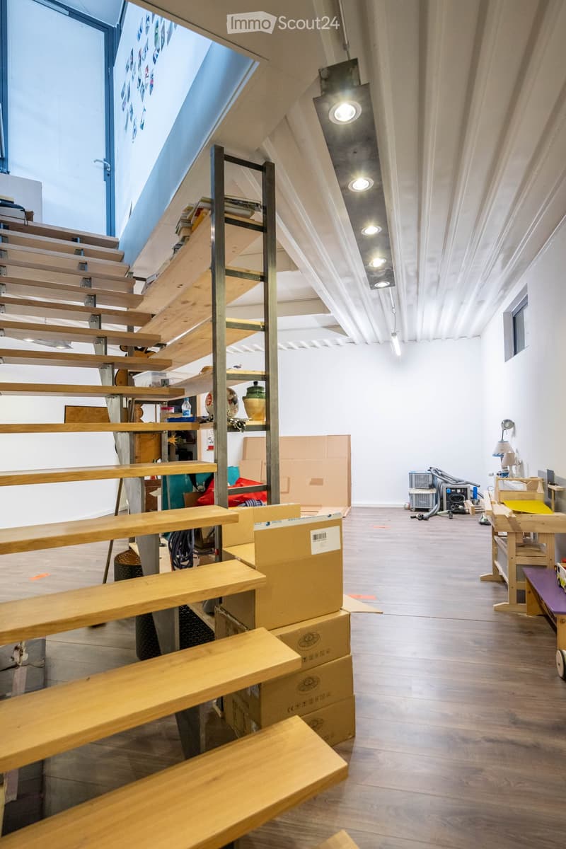 wooden stairs, wooden floor, white walls, metal shelves, boxes, lamps, ceiling lights