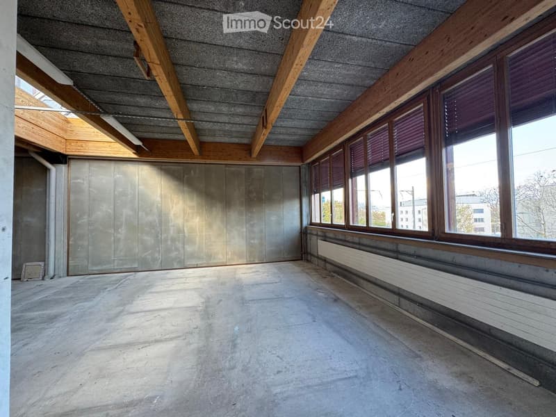 empty room, concrete floor, wooden beams, large windows, radiator