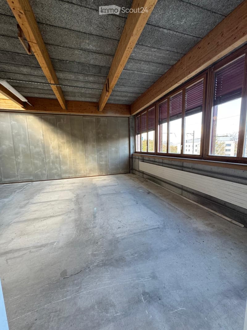 empty room, concrete floor, wooden beams, large windows, metal wall