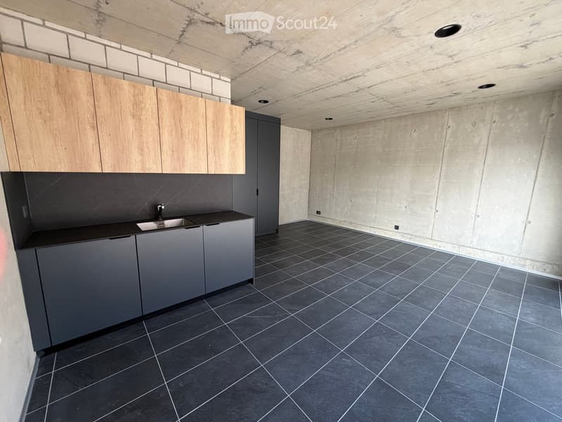 modern kitchen with wooden cabinets, black countertops, stainless steel sink, tiled floor