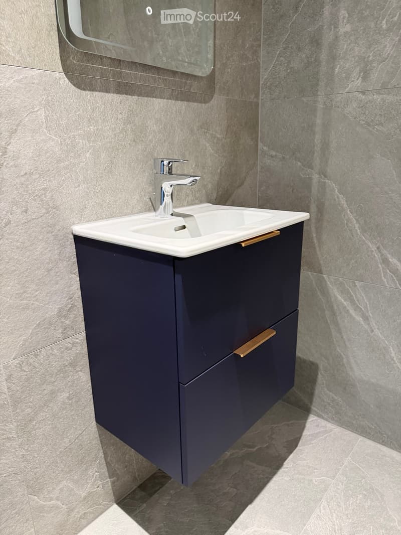 Bathroom vanity with a sink, blue cabinet, silver faucet, and two drawers