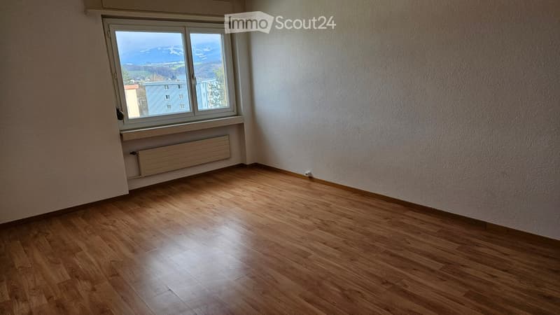 empty room, wooden floor, white walls, large window, view of mountains