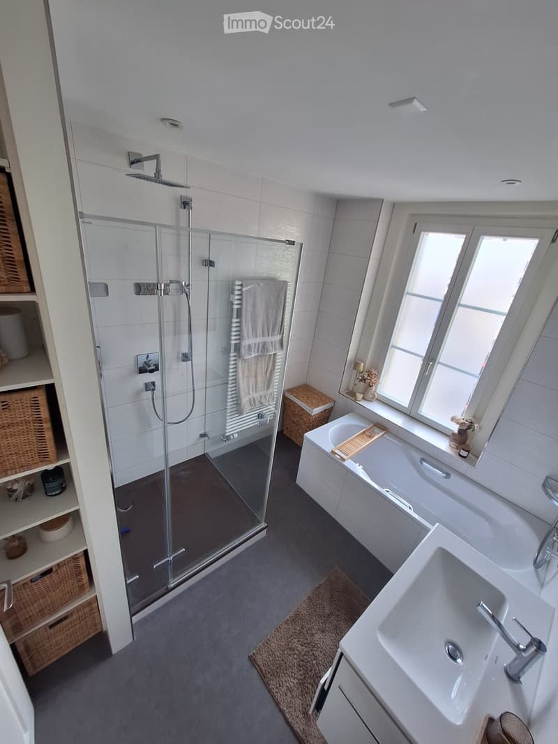 modern bathroom with shower, bathtub, sink, and window