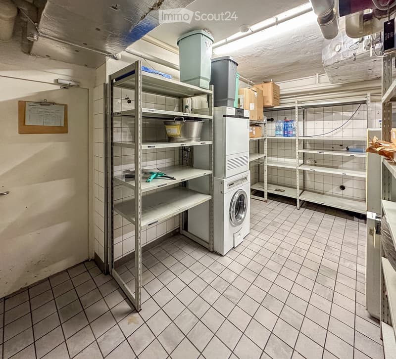 Storage room with shelves, washing machine, buckets, boxes, and a clipboard on the wall