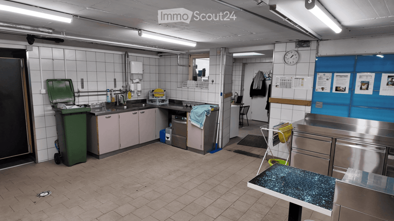 stainless steel counters, tiled floor, washing machine, industrial dishwasher, trash bin, sink