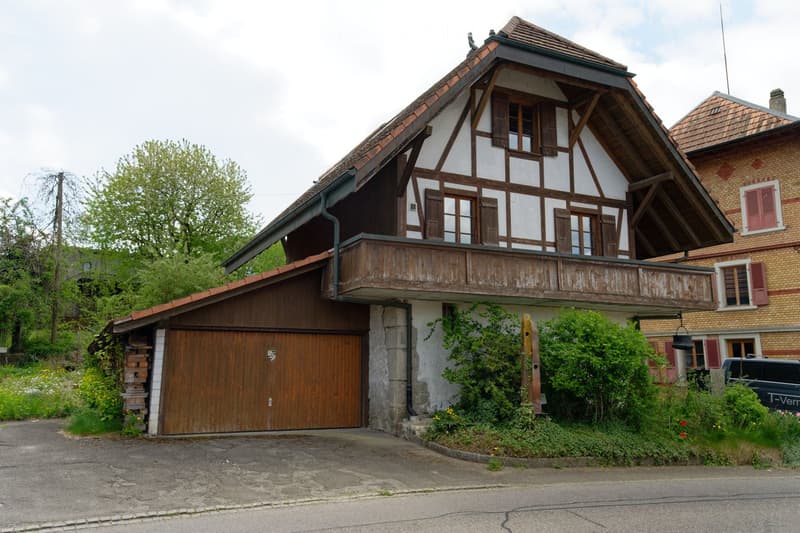 Traditional house, wooden garage, wooden balcony, red roof, brick walls
