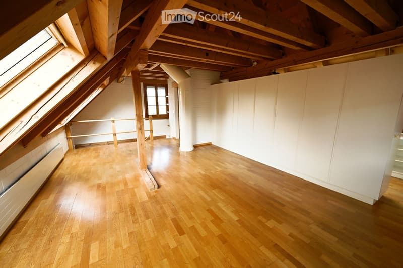 wooden floor, wooden beams, white walls, windows, radiator