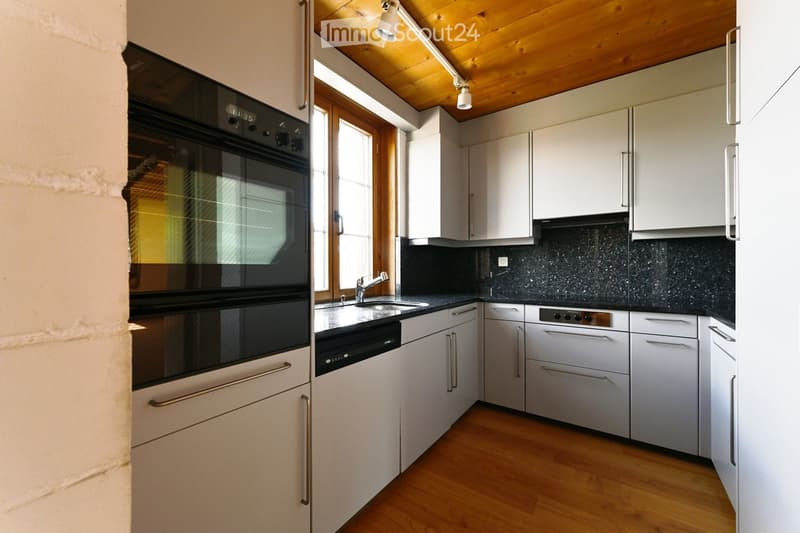 modern kitchen with white cabinets, black granite countertops, stainless steel appliances, wooden floor