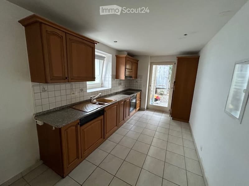 kitchen with wooden cabinets, granite countertop, sink, dishwasher, window