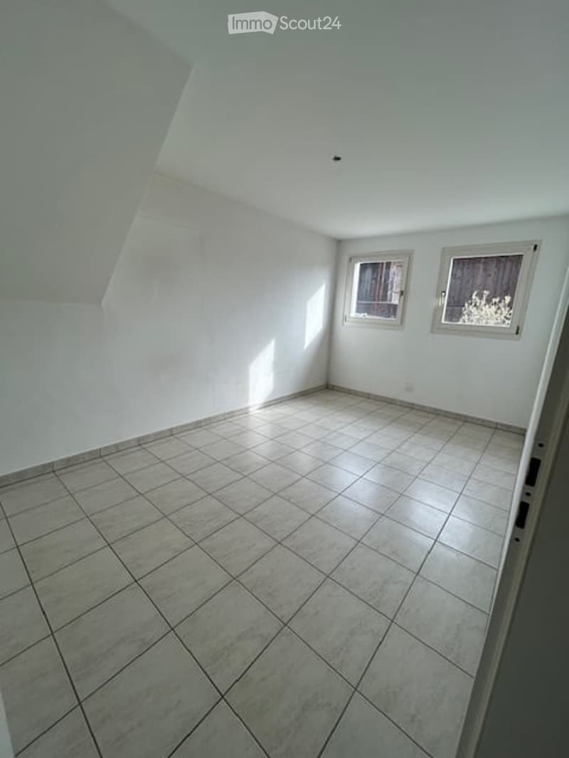 Empty room with white tiled floor, white walls, two windows, and a ceiling light