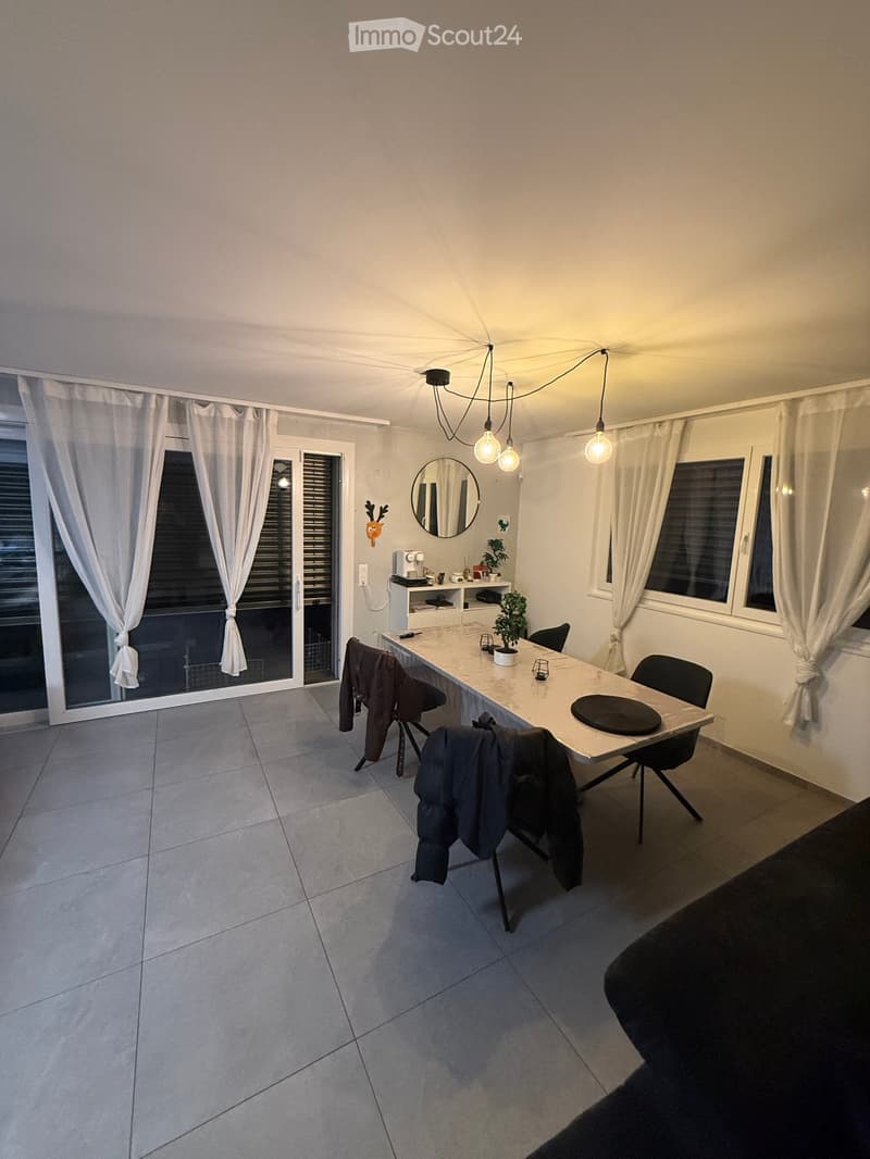 Dining room with a large table, chairs, and a balcony with a view