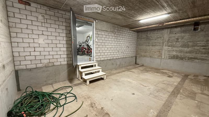 underground room, white brick walls, open door, bicycles, white steps, green hoses
