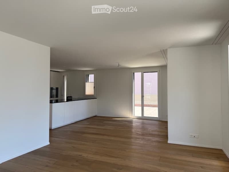empty room, wooden floor, white walls, sliding glass doors, balcony, kitchen area
