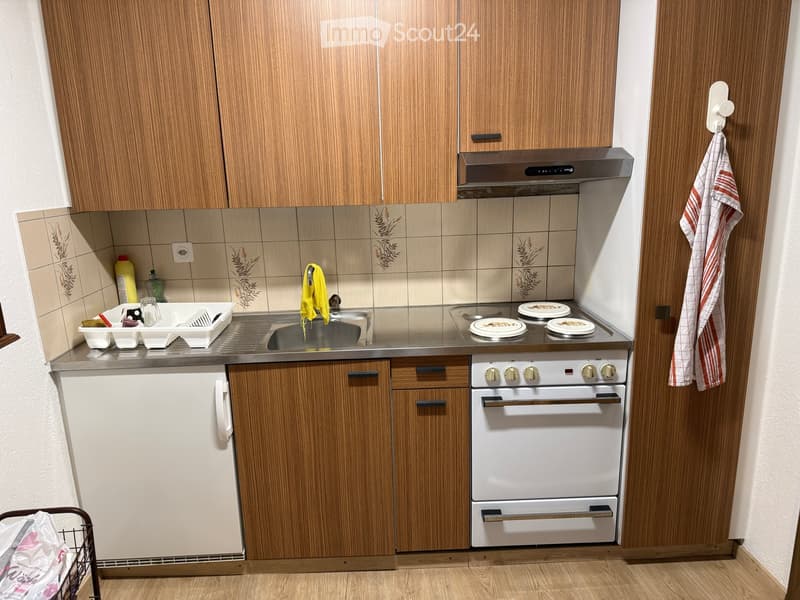 wooden cabinets, stainless steel countertop, sink, gas stove, oven, dishwasher, washing machine