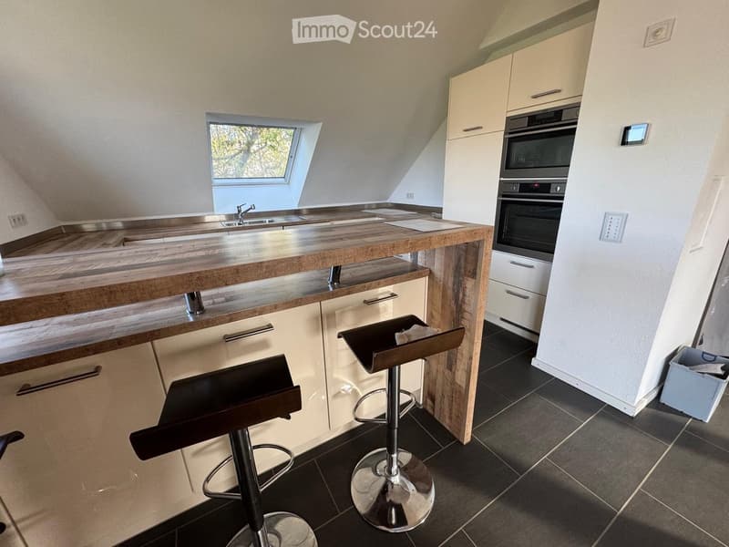 kitchen with wooden counter, two stools, white cabinets, oven, sink, window