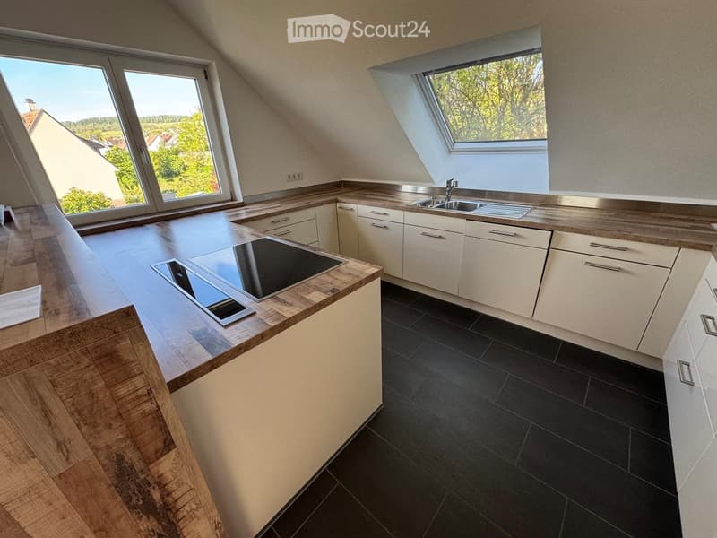 modern kitchen with wooden countertops, black tiled floor, white cabinets, stainless steel sink, induction cooktop, skylights