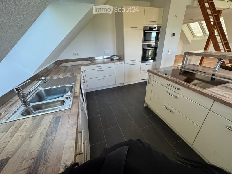 modern kitchen, wooden countertops, stainless steel sink, white cabinets, tiled floor, double oven, wooden ladder