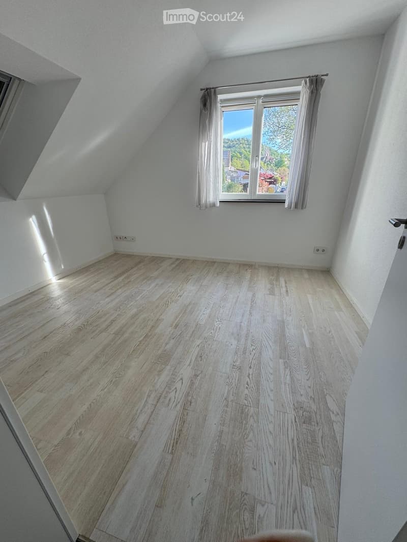 empty room, wooden floor, white walls, window with curtains, power outlets