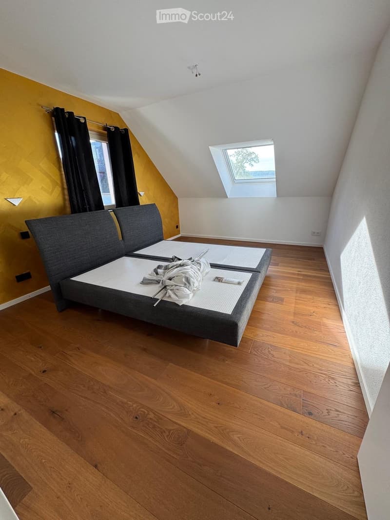 Empty room with wooden floor, two beds, yellow wall, black curtains, skylight window