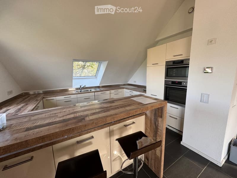 modern kitchen with wooden counter, white cabinets, stainless steel appliances, skylight window