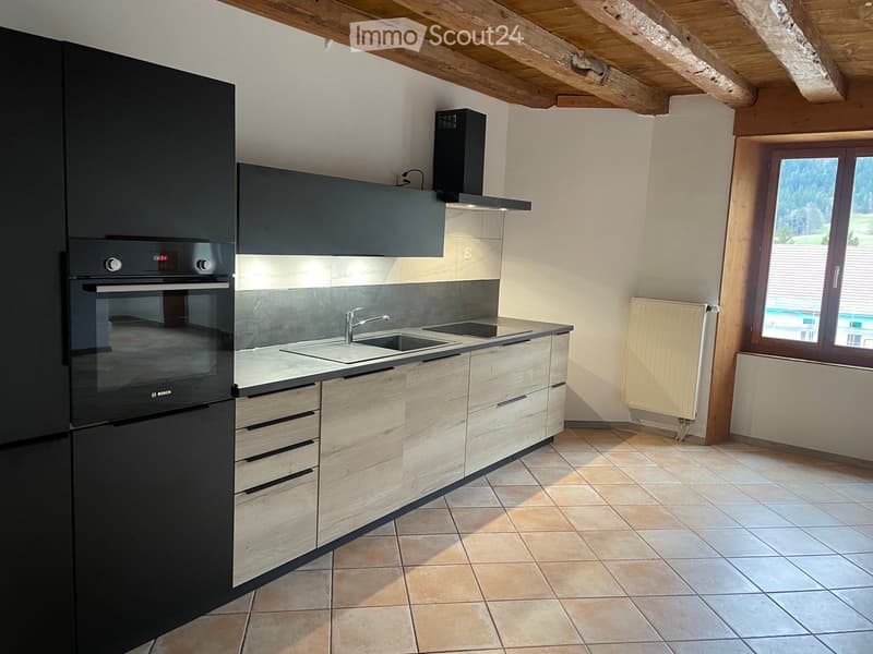 modern kitchen with wooden cabinetry, tiled flooring, black appliances, and a built-in oven, sink, and faucet