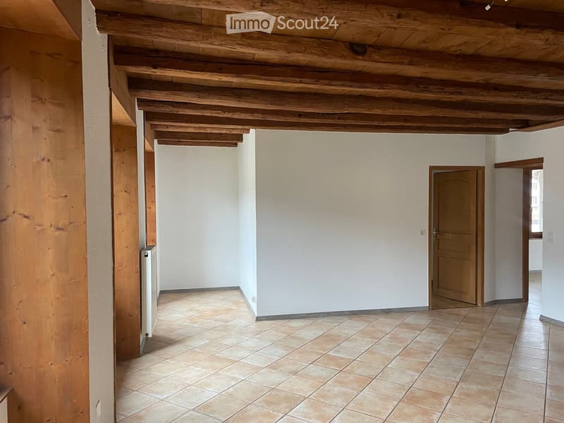 empty room with wooden ceiling, tiled floor, two white walls, wooden door, small window