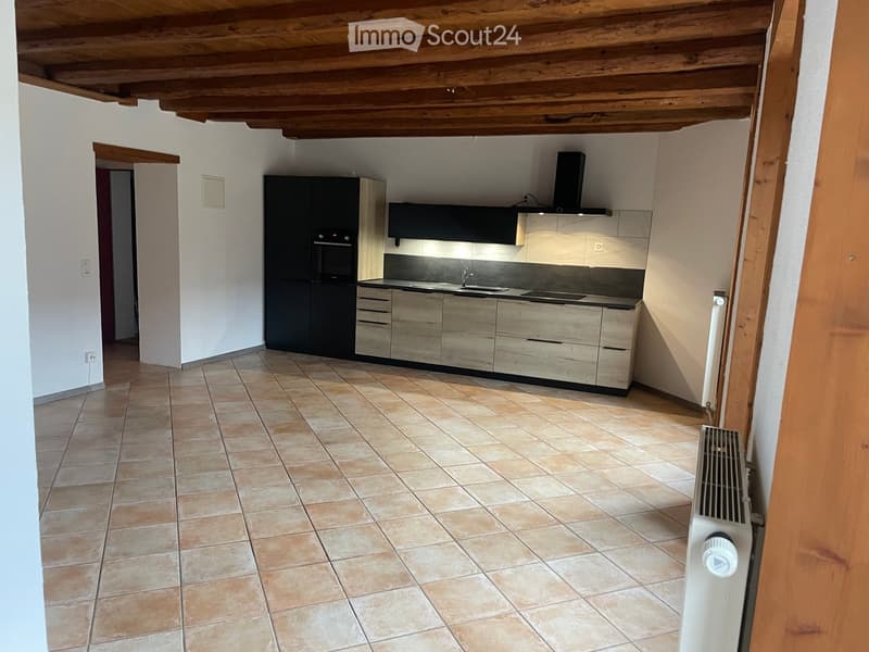 empty kitchen, white walls, wooden ceiling, tile flooring, dark cabinets, central island, sink, faucet, stove, oven, and extractor fan